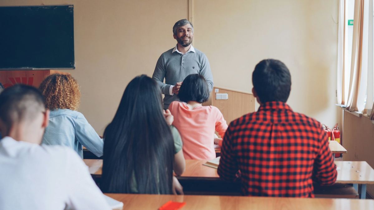 A teacher leading a class while students listen