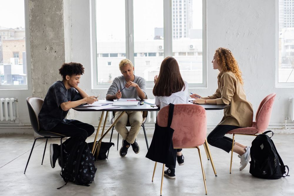 Students meeting around a table for a class discussion